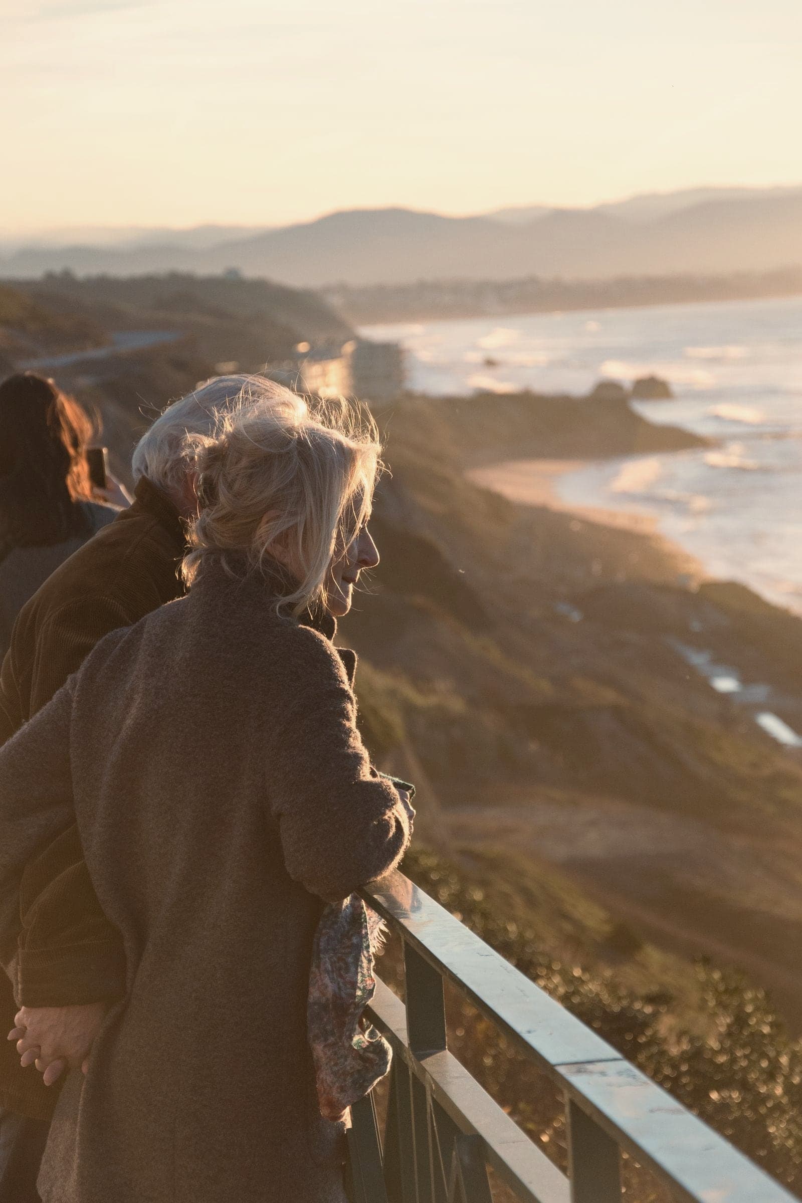 Un couple âgé, main dans la main, regarde le soleil se coucher sur la côte basque.